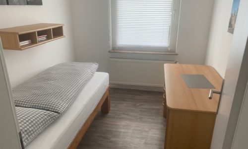 Kleines Schlafzimmer mit Schreibrtisch in der Ferienwohnung Heppenheim